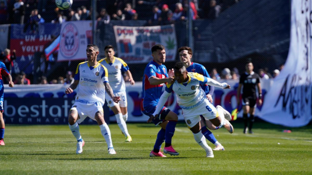 Jaminton Campaz ya impactó la pelota y Ángel Di María sigue la trayectoria.