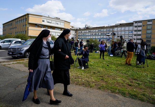 Dos monjas caminan frente al hospital donde está internado Francisco y en cuyo parque se concentra una permanente guardia periodística.
