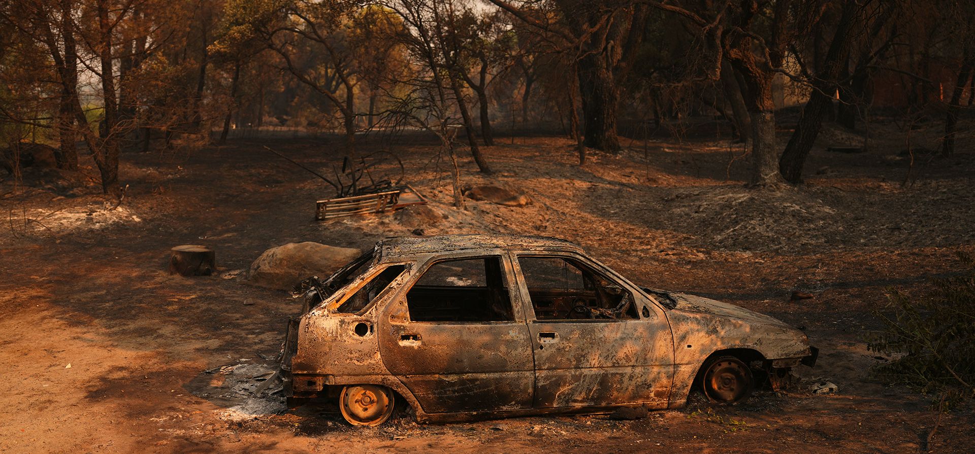 Un coche calcinado por un incendio forestal permanece en Piedralaves, provincia de Ávila, España, mientras el fuego continúa propagándose, el martes 28 de julio de 2026. (Foto AP/Manu Fernández)