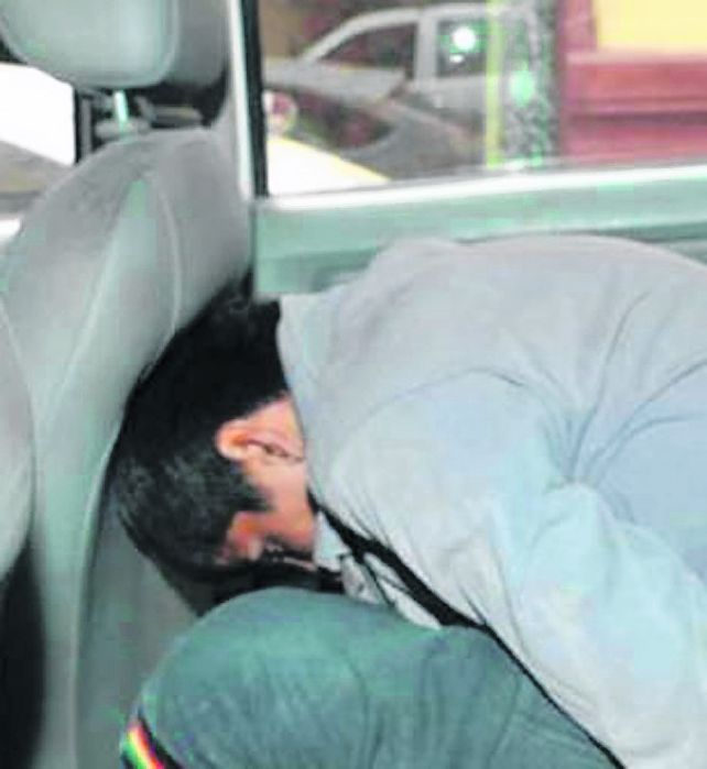 Casi linchado. El joven al ser llevado a la celda de una comisaria.
