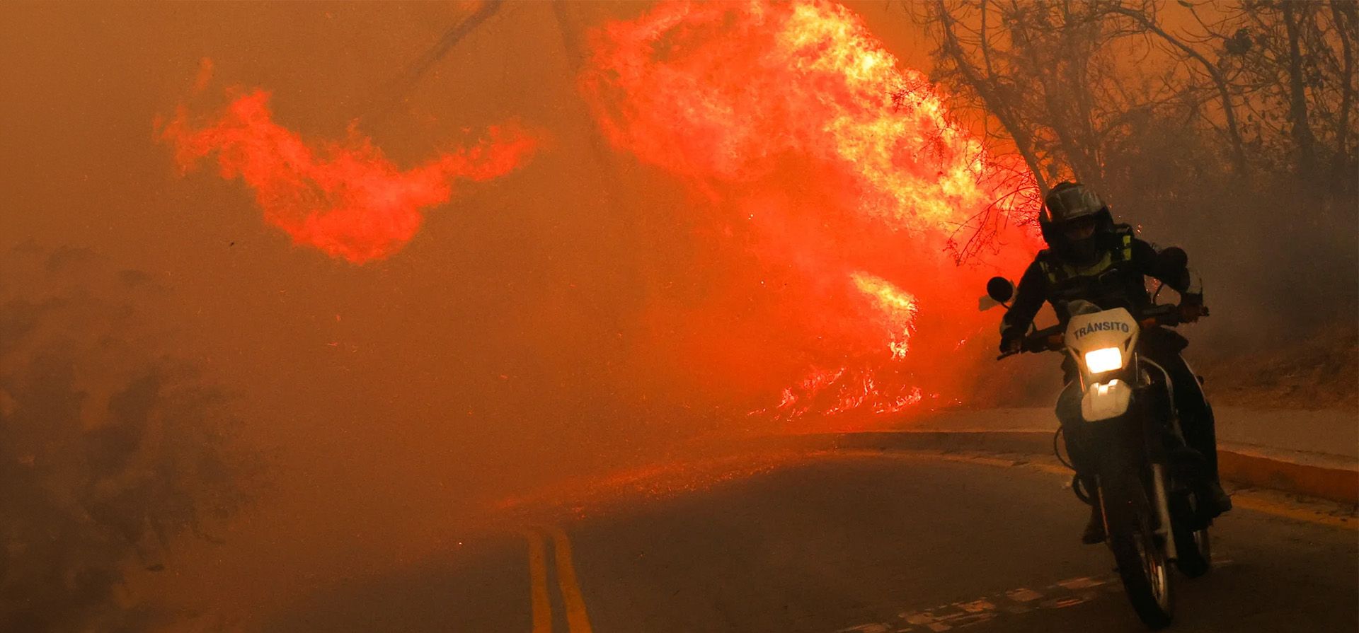 Un motociclista se aleja de un incendio forestal. La ciudad se ha visto afectada por la peor sequía en seis décadas y por incendios forestales que han afectado a unas 40.000 hectáreas, Quito, Ecuador. Fotografía: Karen Toro/Reuters Un motociclista se aleja de un incendio forestal. La ciudad se ha visto afectada por la peor sequía en seis décadas y por incendios forestales que han afectado a unas 40.000 hectáreas, Quito, Ecuador. Fotografía: Karen Toro/Reuters