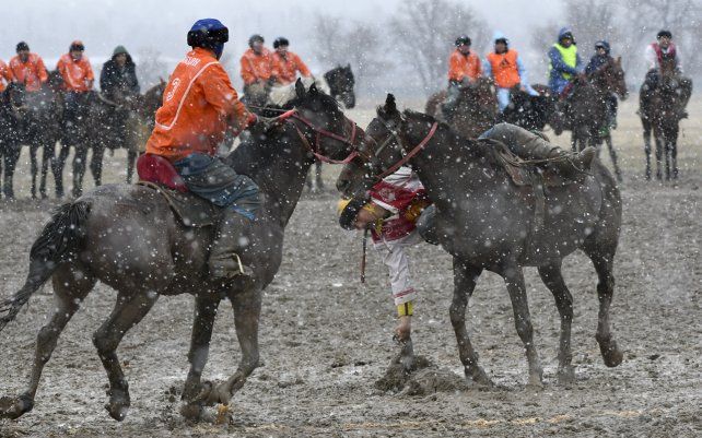 Un grupo de jinetes compiten durante un kok boru, juego tradicional en el que los jugadores a caballo maniobran con el cadáver de una cabra y anotan colocándolo en la portería de los oponentes. La competencia se desarrolla en la aldea de Sokuluk, Kirguistán, Asia Central.