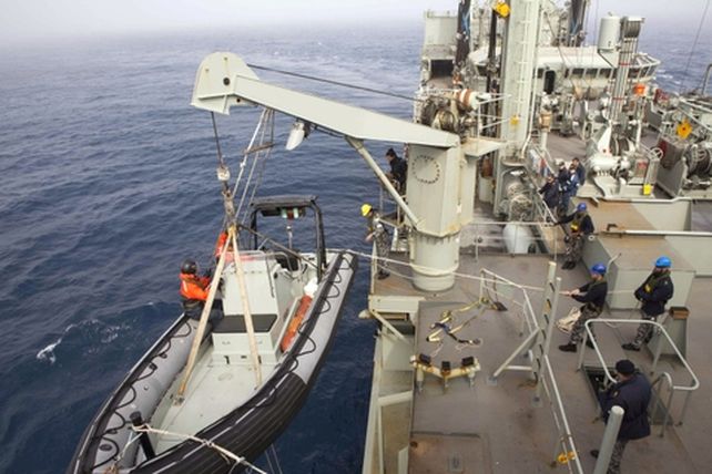 Un bote inflable es bajado en el sur del Océano Índico en busca de restos del vuelo MH370.