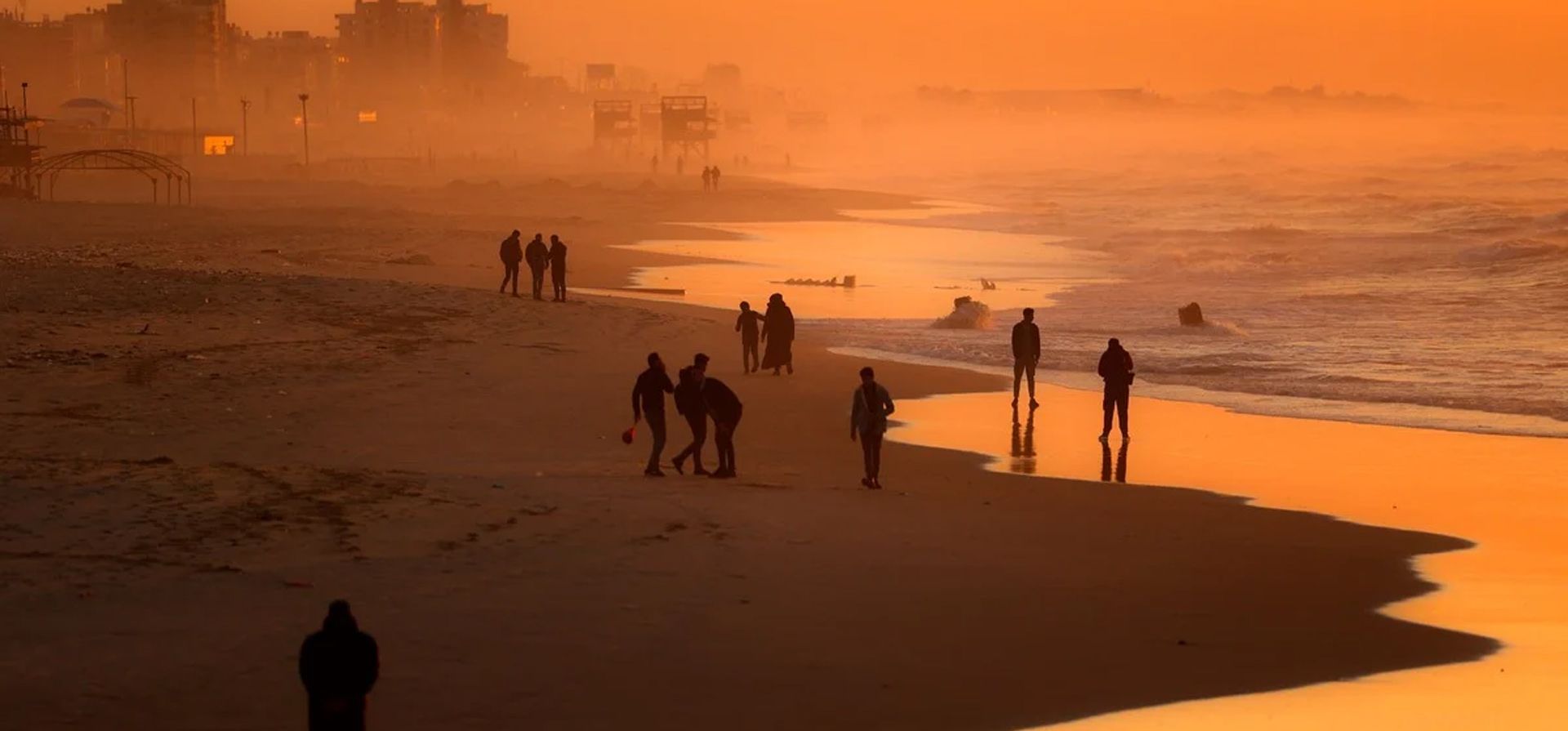 Ciudadanos palestinos caminan por la playa en la ciudad de Gaza, el 29 de diciembre de 2021. Foto: AFP