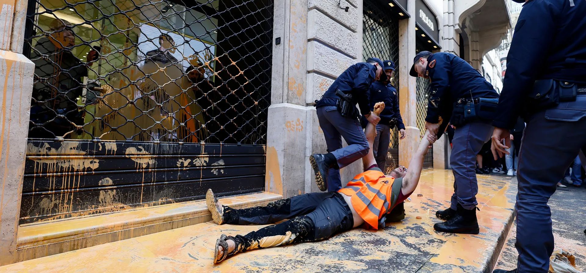 Un activista climático de la Última Generación es arrastrado por agentes de policía después de arrojar pintura lavable en el escaparate de una tienda de Prada en la elegante Via Condotti de la ciudad, Roma, Italia. Fotografía: Cecilia Fabiano/AP Un activista climático de la Última Generación es arrastrado por agentes de policía después de arrojar pintura lavable en el escaparate de una tienda de Prada en la elegante Via Condotti de la ciudad, Roma, Italia. Fotografía: Cecilia Fabiano/AP