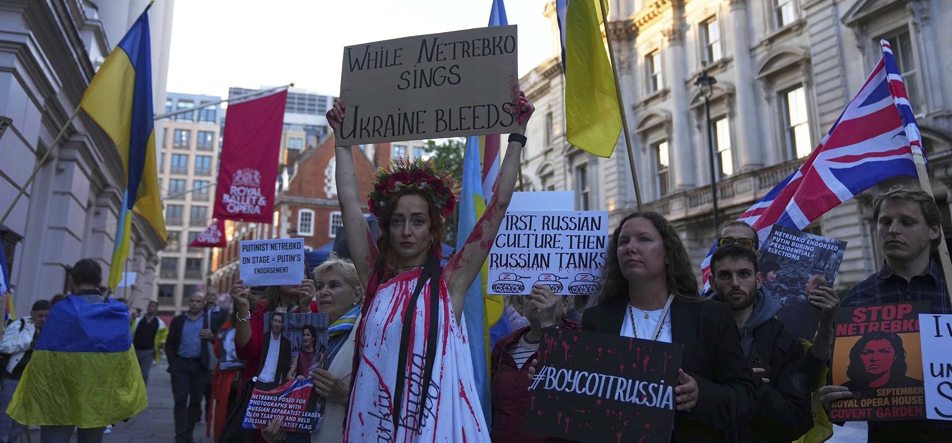 Manifestantes pro-Ucrania sostienen pancartas y banderas durante una protesta contra el Teatro Real de Ópera de Londres, ya que la casa había designado a una cantante de ópera rusa para interpretar el papel principal en la ópera Manifestantes pro-Ucrania sostienen pancartas y banderas durante una protesta contra el Teatro Real de Ópera de Londres, ya que la casa había designado a una cantante de ópera rusa para interpretar el papel principal en la ópera