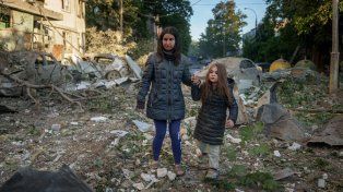 Una madre y su hija salen de su casa en Kiev después de un ataque ruso.
