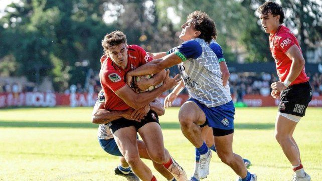 El santafesino Juan Cruz Strada intenta detener el avance de un jugador de Dogos.