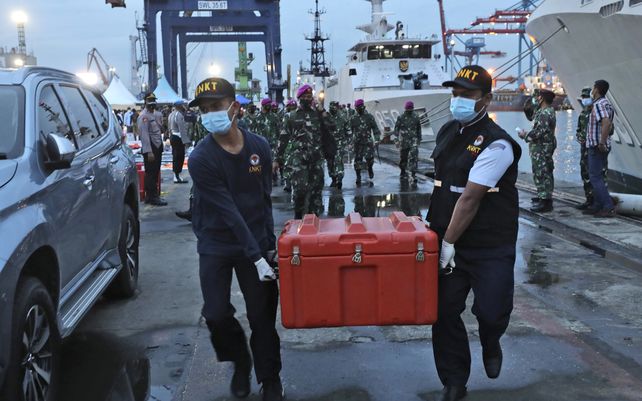 Miembros del Comité Nacional de Seguridad del Transporte llevan la caja que contiene el registrador de datos de vuelo del vuelo SJ-182 de Sriwijaya Air recuperado del mar de Java donde el avión de pasajeros se estrelló.