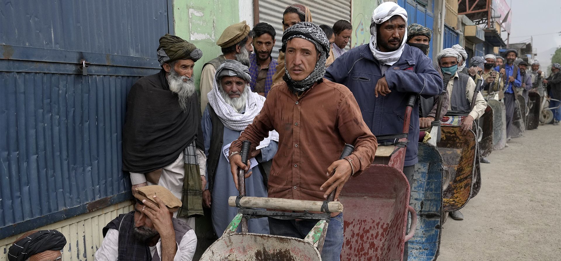 Un grupo de residentes de Kabul esperan para recibir las raciones de alimentos distribuidas por un grupo de ayuda humanitaria de Corea del Sur, Afganistán, el martes 10 de mayo de 2022.