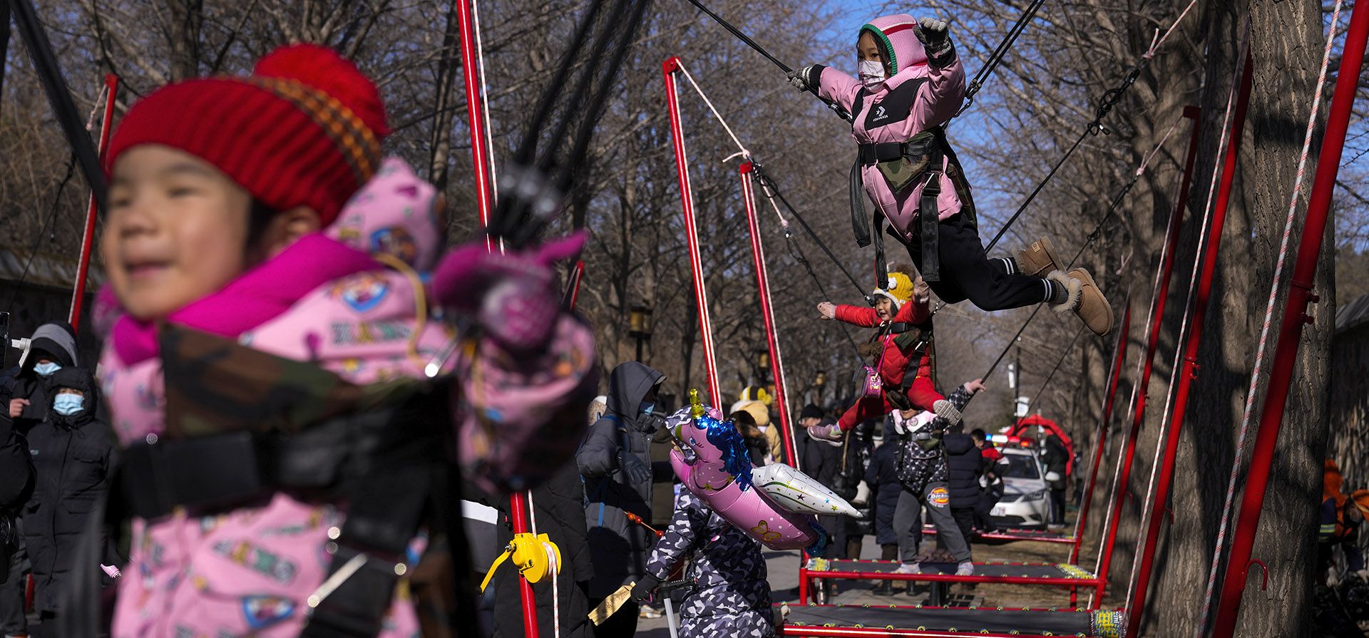 Niños juegan en los trampolines mientras la gente visita una feria del templo en el Jardín Yuanmingyuan durante el segundo día de las celebraciones del Año Nuevo Lunar en Beijing, el lunes 23 de enero de 2023. El Año Nuevo Lunar es la festividad anual más importante en China. (Foto AP/Andy Wong)