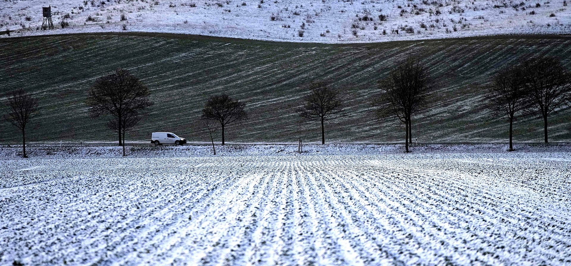 Un automóvil circula por una carretera entre campos cubiertos de nieve cerca de Wernigerode, Alemania, el miércoles 14 de diciembre de 2022. (Foto AP/Matthias Schrader)