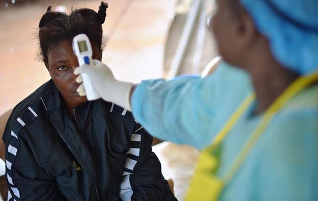 Una médica toma la temperatura a una niña en Monrovia. La gente reaccionó ante las autoridades.