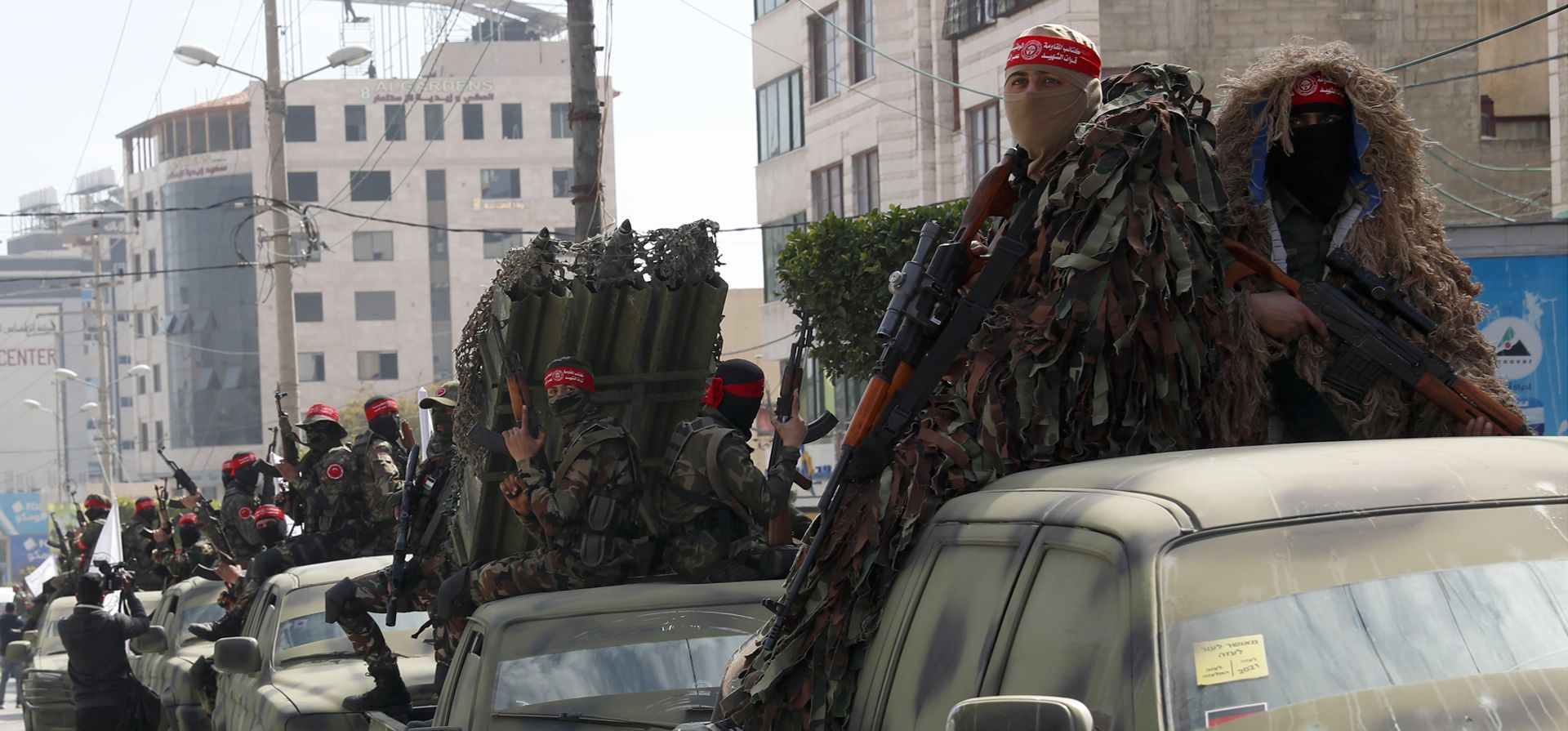 Militantes palestinos del Frente Democrático para la Liberación de Palestina (FDLP) sostienen sus armas en la parte trasera de camiones, durante una manifestación para conmemorar el 53° aniversario del movimiento en las calles de la ciudad de Gaza, el martes 22 de febrero de 2022.