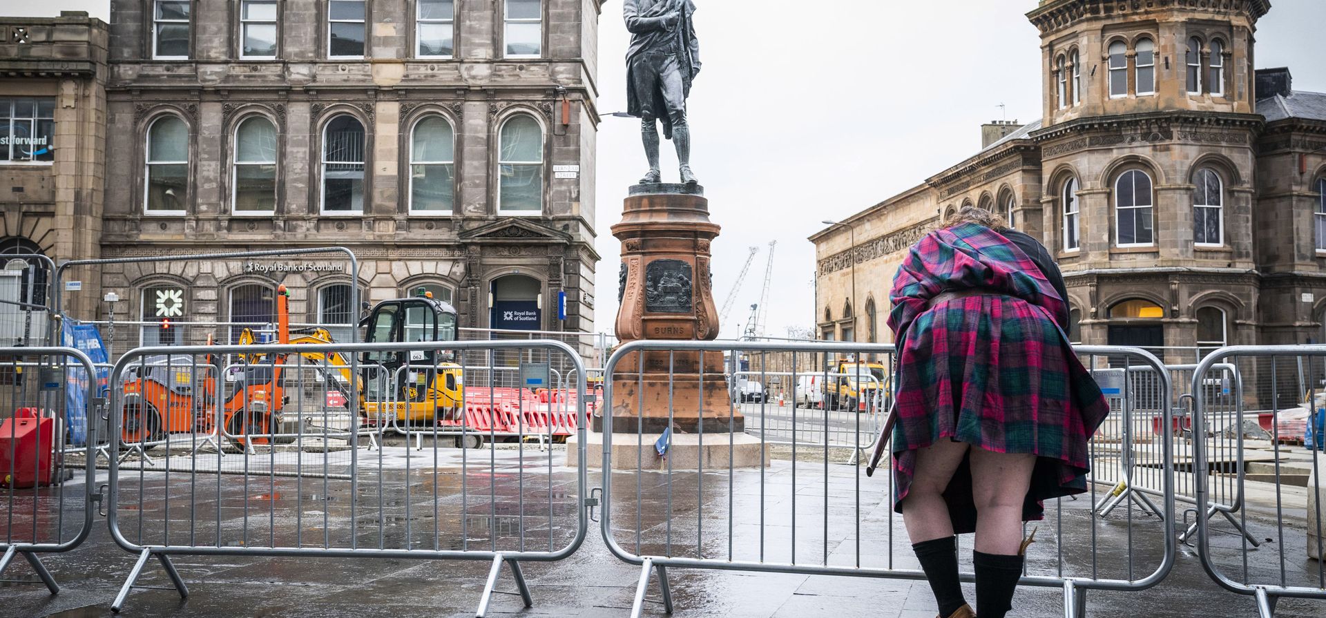 Una mujer echa observa de cerca a la estatua de 124 años del poeta Socttish Robert Burns después de que fuera inaugurada en una ceremonia para marcar su regreso, en Baltic Street en Leith, Edimburgo, Escocia, el martes 25 de enero de 2022 La estatua fue retirada en 2019 como parte de las obras del tranvía de Edimburgo.
