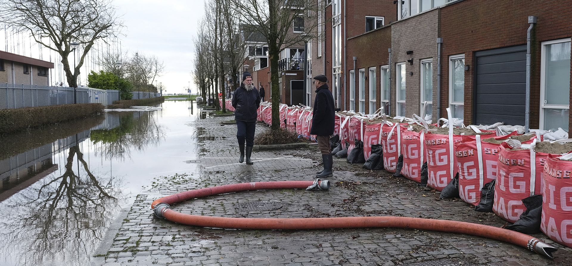 La gente pasa por una calle inundada protegida por sacos de arena en Hoorn, Países Bajos, el jueves 4 de enero de 2024. Hoorn ha sido amenazado por la crecida del lago Markermeer en sus afueras. (Foto AP/Mike Corder La gente pasa por una calle inundada protegida por sacos de arena en Hoorn, Países Bajos, el jueves 4 de enero de 2024. Hoorn ha sido amenazado por la crecida del lago Markermeer en sus afueras. (Foto AP/Mike Corder