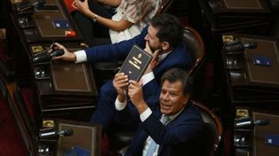 Facundo Manes le muestra a Javier Milei un ejemplar de la Constitución nacional mientras el presidente daba su discurso ante la Asamblea Legislativa.