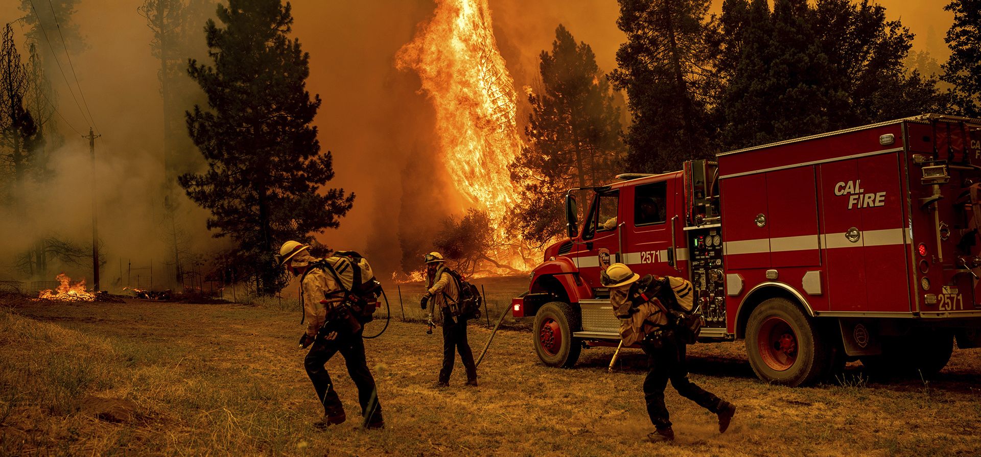 Los bomberos trabajan para evitar que Oak Fire llegue a una casa en la comunidad de Jerseydale del condado de Mariposa, California.
