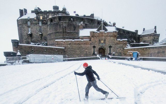 Una mujer esquía por la explanada del Castillo de Edimburgo. La tormenta Christoph trae condiciones climáticas desafiantes para el Reino Unido.