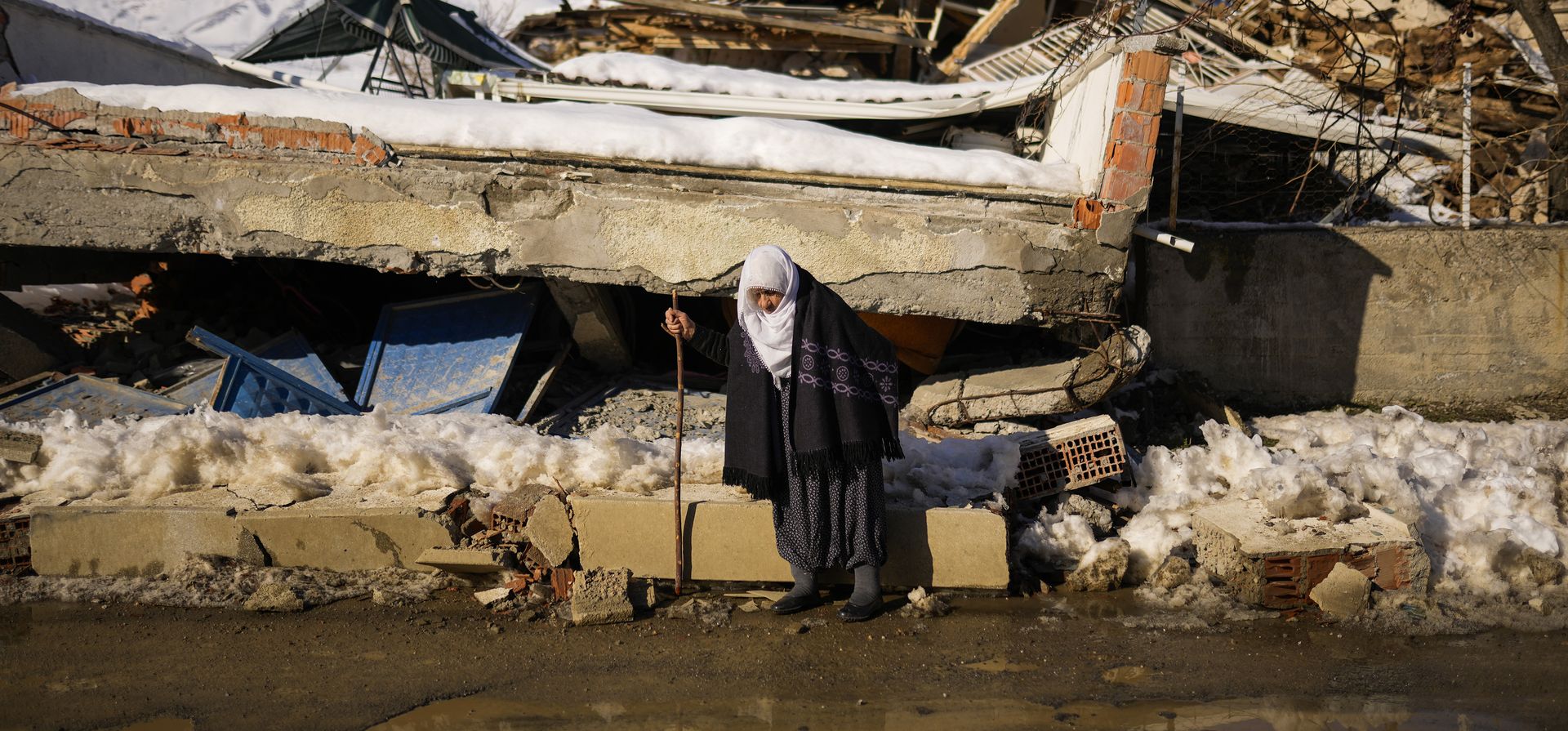 Una anciana pasa frente a una casa destruida en la aldea de Polat, Turquía, el domingo 12 de febrero de 2023. Cinco días después de que dos poderosos terremotos con horas de diferencia provocaran el derrumbe de decenas de edificios, lo que provocó la muerte de miles de personas y dejó a millones sin hogar, los rescatistas aún estaban sacando supervivientes improbables de las ruinas. (Foto AP/Francisco Seco)
