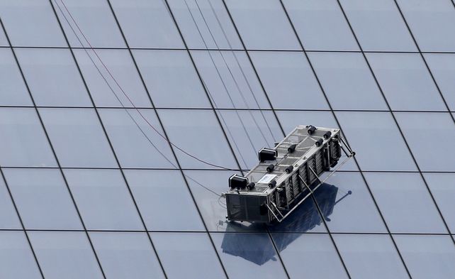 Un andamio con dos operarios, a punto de caer de una gran torre de Nueva York