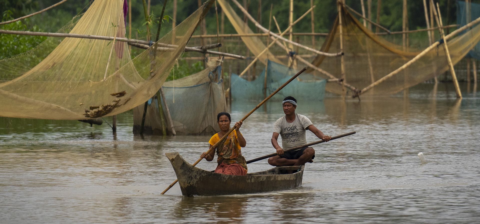 Miembros de la tribu Mishing reman en botes para pescar en el río Janji en el alto Assam, al este de Guwahati, India, el lunes 26 de septiembre de 2022. (