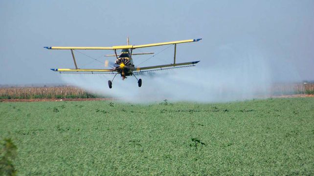 Una avioneta fumiga la cosecha en una zona rural.