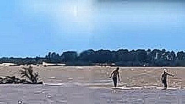 Concepción del Uruguay: imprudentes caminan sobre la muralla cubierta por el río.