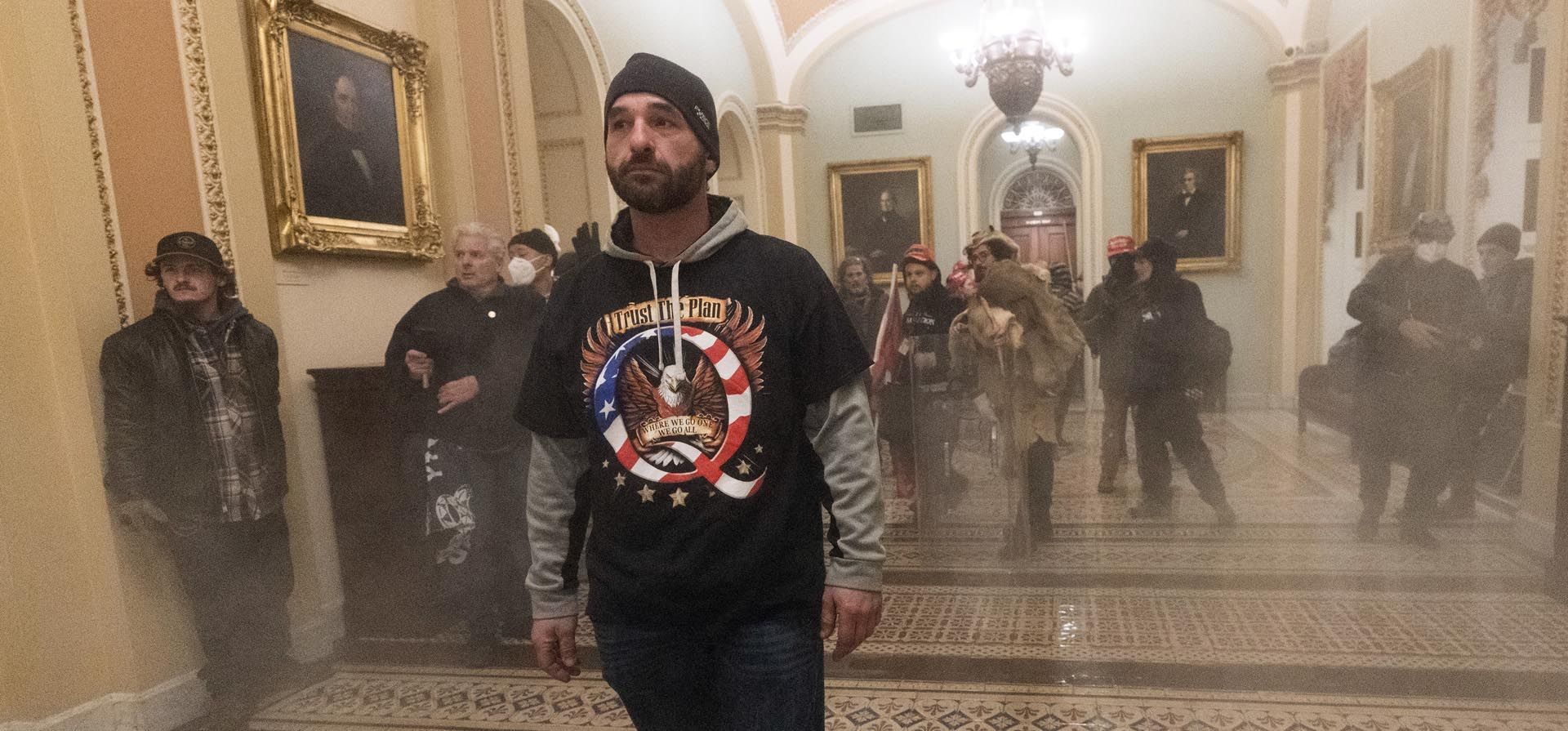Simpatizantes del presidente Donald Trump gesticulan a la policía del Capitolio de los Estados Unidos en el pasillo fuera de la cámara del Senado en el Capitolio en Washington, el 6 de enero de 2021. 