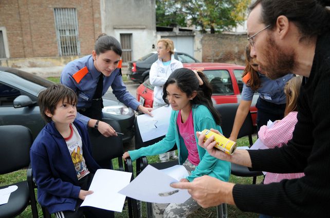 Agentes de la Policía Comunitaria junto a chicos y vecinos realizando el mural.
