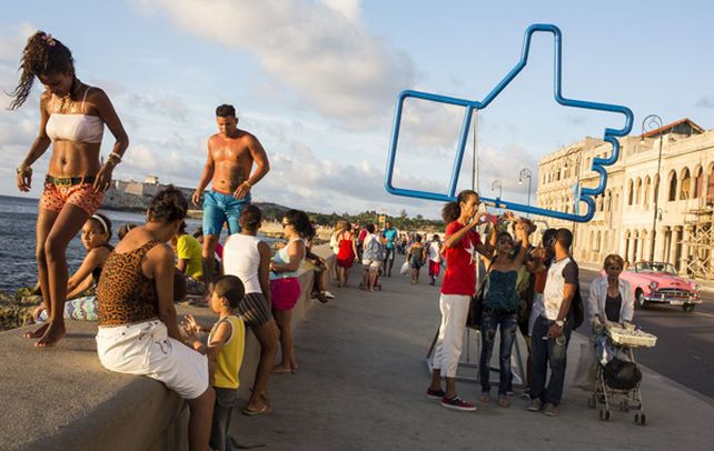 La gente transita por el paseo habanero cerca de la obra “Suite Emotion”