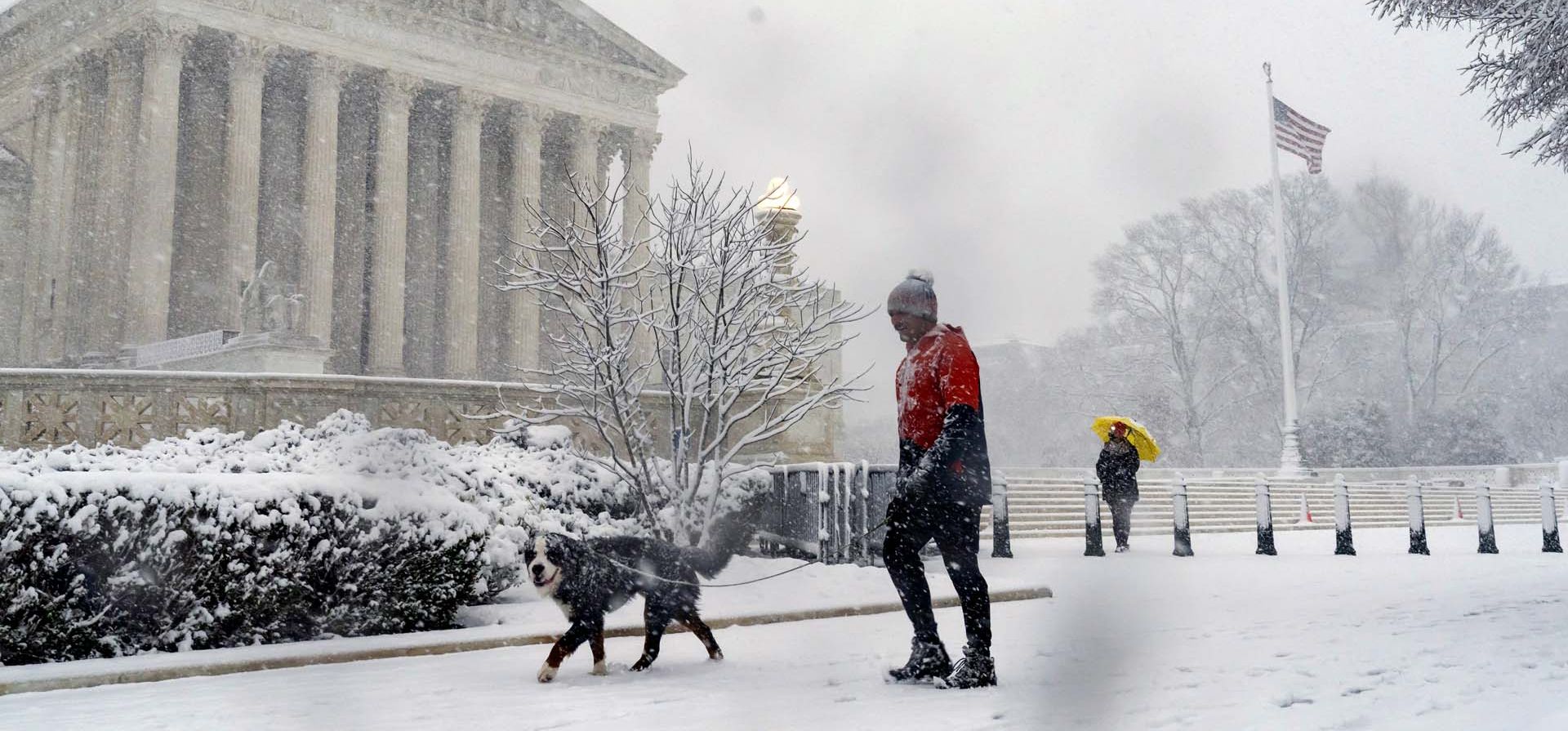 Un hombre pasea a su perro frente a la Corte Suprema mientras una tormenta invernal trae fuertes nevadas al Capitolio en Washington. Foto: AP