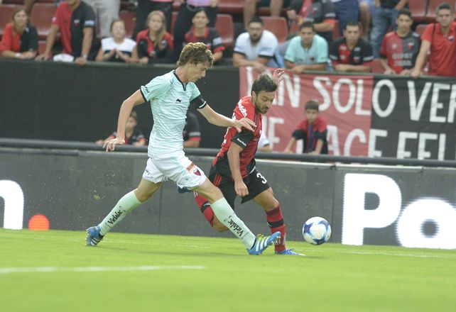 Paso por acá. Scocco engancha ante Conti para ir hacia el arco sabalero. Nacho anotó de penal y puso en ventaja a Newells.