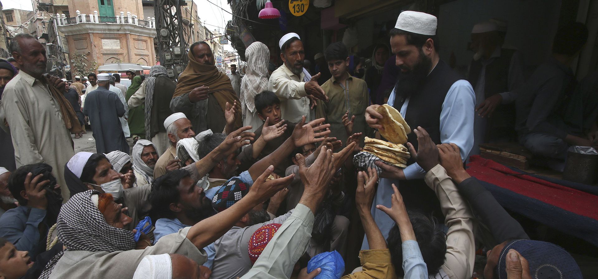 La gente recibe pan gratis distribuido por un voluntario para romper el ayuno durante el mes sagrado de ayuno musulmán del Ramadán frente a un restaurante en Peshawar, Pakistán, el jueves 4 de abril de 2024. (Foto AP/Muhammad Sajjad) La gente recibe pan gratis distribuido por un voluntario para romper el ayuno durante el mes sagrado de ayuno musulmán del Ramadán frente a un restaurante en Peshawar, Pakistán, el jueves 4 de abril de 2024. (Foto AP/Muhammad Sajjad)