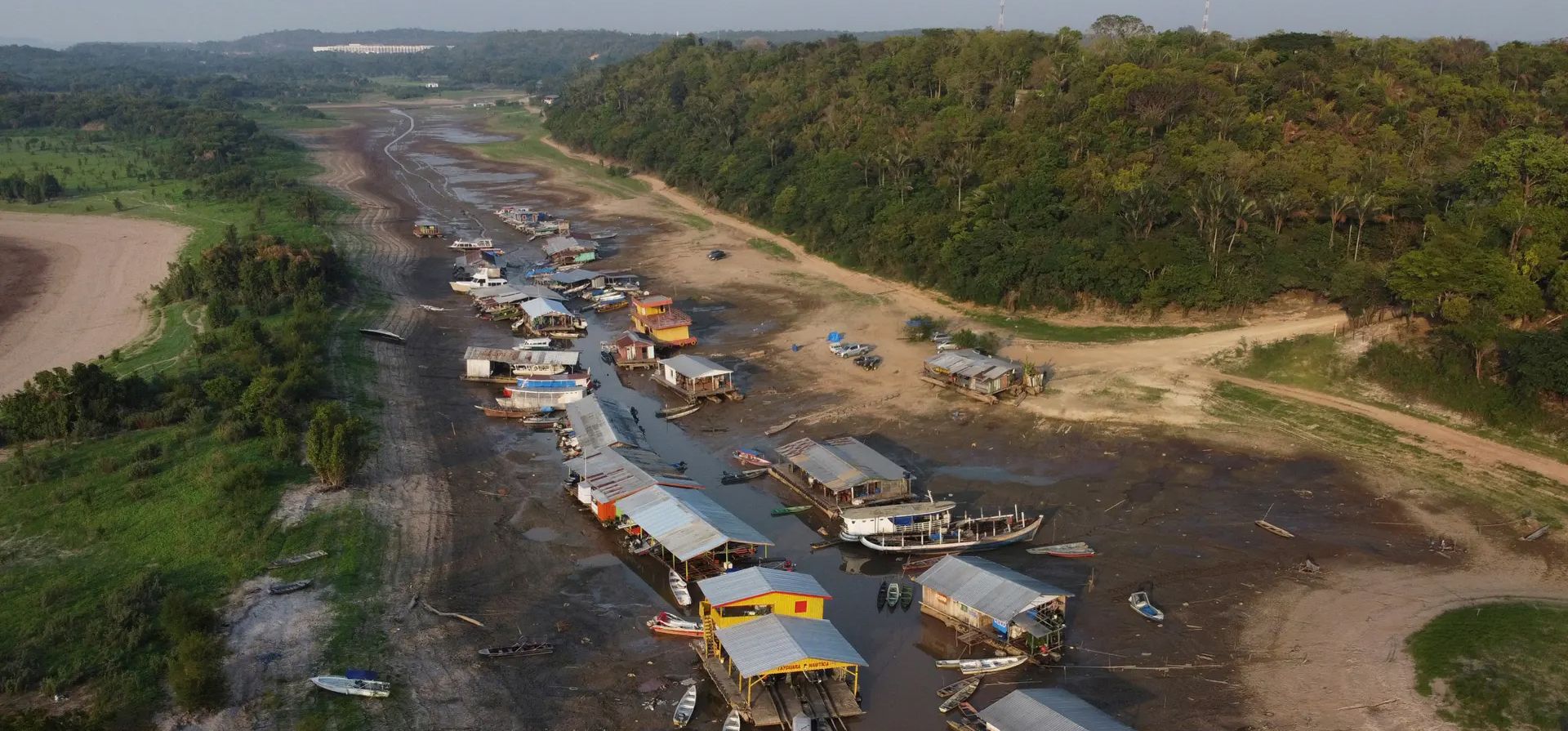 Manaos, Brasil. Casas flotantes y botes yacen varados en el lecho seco del lago Puraquequara durante una severa sequía en el estado de Amazonas. Fotografía: Edmar Barros/AP Manaos, Brasil. Casas flotantes y botes yacen varados en el lecho seco del lago Puraquequara durante una severa sequía en el estado de Amazonas. Fotografía: Edmar Barros/AP