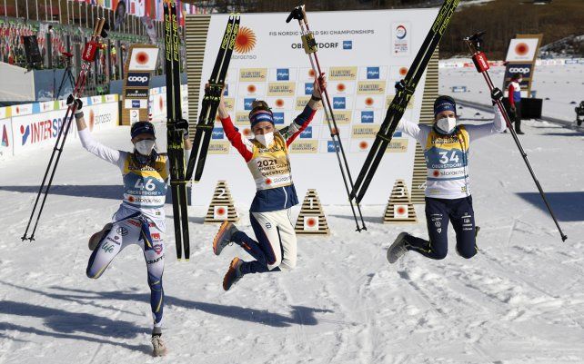 La ganadora Therese Johaug de Noruega, en el centro, celebra flanqueada por la segunda, Frida Karlsson de Suecia, a la izquierda, y la tercera, Ebba Andersson de Suecia, después de la carrera libre de 10 km de intervalo femenino en el Campeonato Mundial de Esquí Nórdico FIS en Oberstdorf, Alemania.