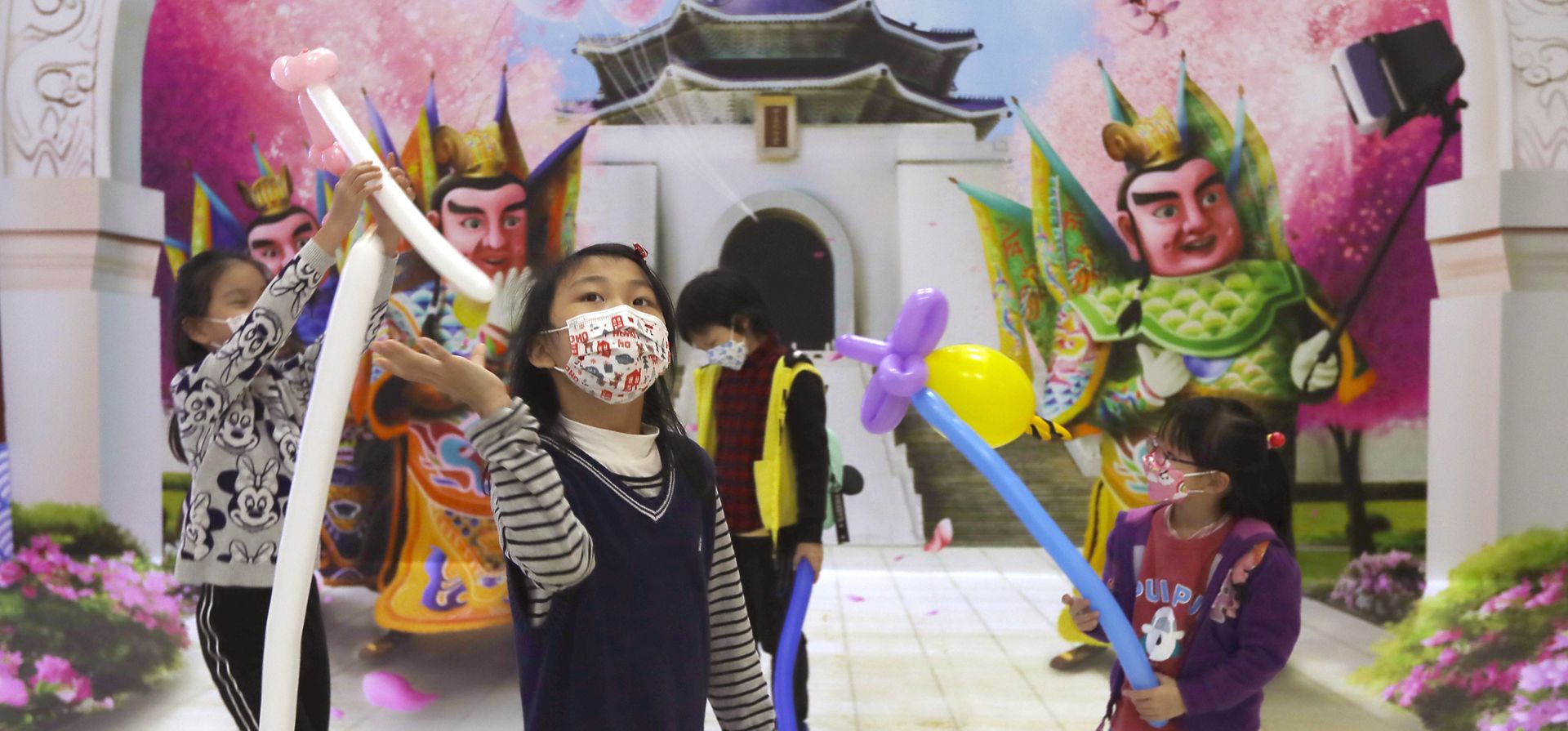 Niños con máscaras faciales para ayudar a protegerse contra la propagación del coronavirus juegan en una galería de pintura #D de puntos de referencia taiwaneses en Taipei, Taiwán, el lunes 24 de enero de 2022.