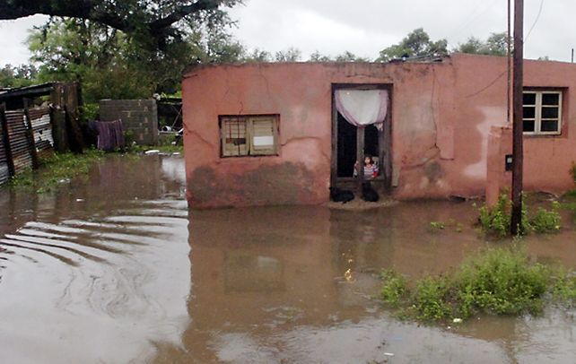 en la puerta. Una nena mira el paisaje desde su casa en Balnearia