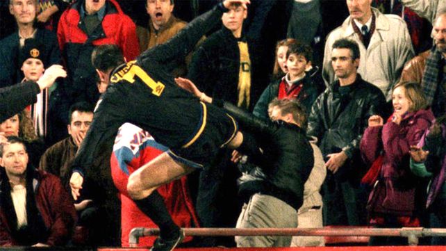 Eric Cantona se arroja para pegarle una patada a un hooligan neonazi luego de escuchar los insultos xenófobos.&nbsp;