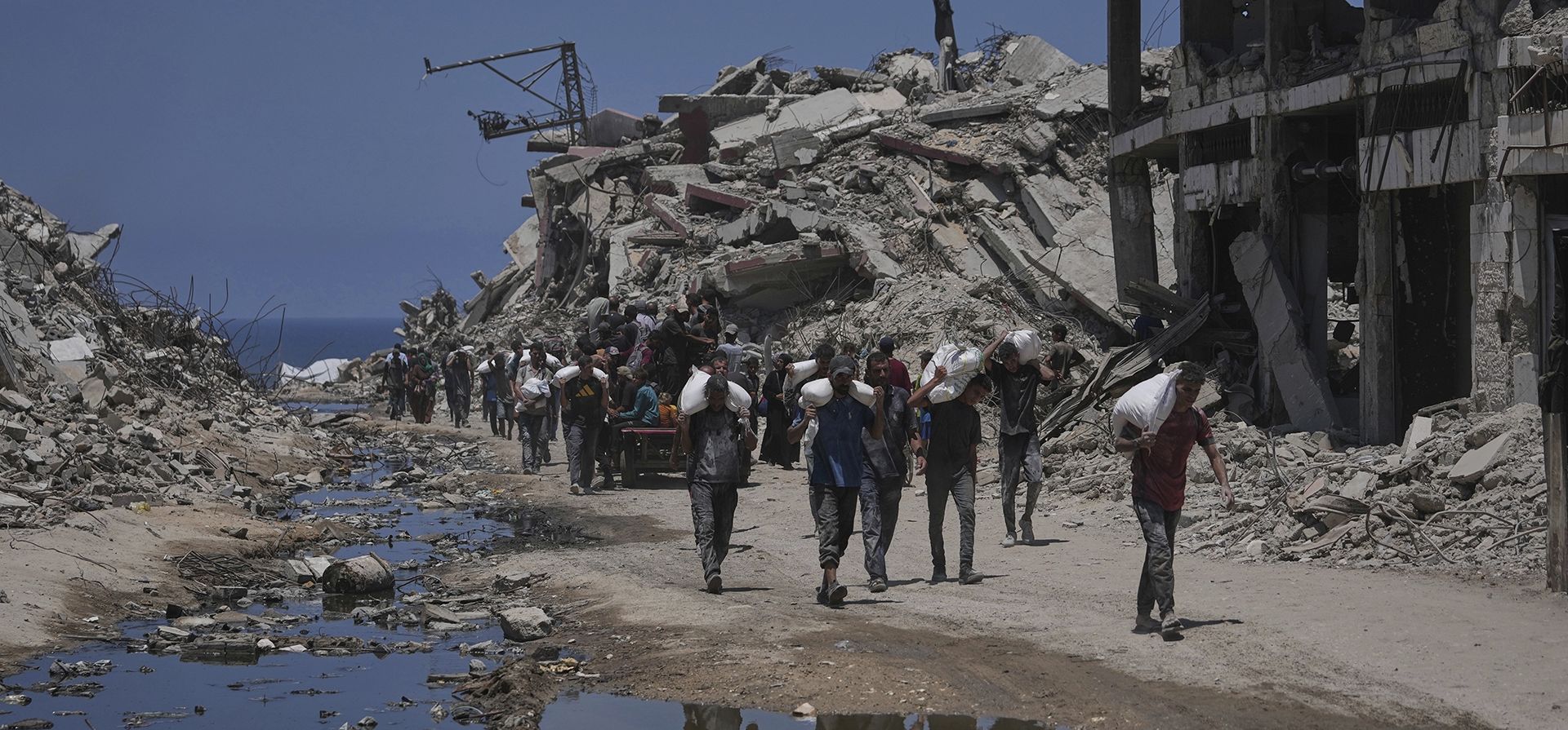 Palestinos cargan sacos de harina descargados de un convoy de ayuda humanitaria que llegó a la ciudad de Gaza desde el norte de la Franja de Gaza, el martes 22 de julio de 2025. (Foto AP/Jehad Alshrafi) Palestinos cargan sacos de harina descargados de un convoy de ayuda humanitaria que llegó a la ciudad de Gaza desde el norte de la Franja de Gaza, el martes 22 de julio de 2025. (Foto AP/Jehad Alshrafi)