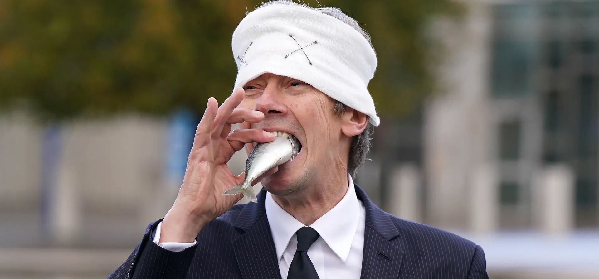 Edimburgo, Reino Unido. Un manifestante de Ocean Rebellion, con los ojos vendados y amordazado con un pez muerto, protesta en las afueras de Holyrood por la cría de salmón. Fotografía: Andrew Milligan/PA