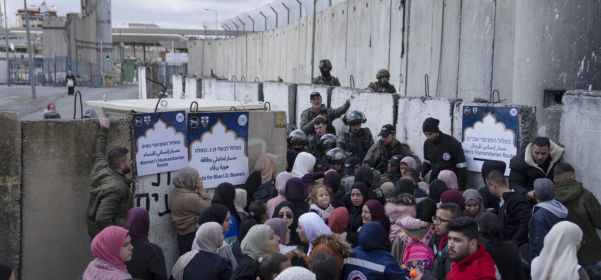 Palestinos pasan por una valla de seguridad mientras cruzan de Cisjordania a Jerusalén, para las oraciones de Ramadán del segundo viernes en el complejo de la mezquita de Al Aqsa, en el puesto de control del ejército israelí de Qalandia, cerca de Ramallah, el viernes 31 de marzo, 2023. (Foto AP/Nasser Nasser)