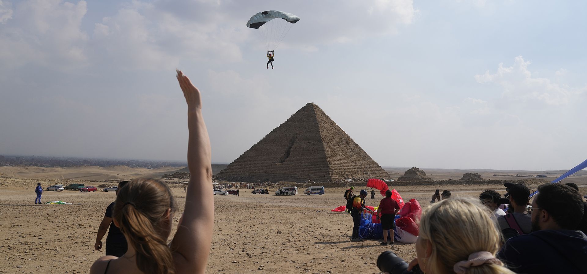 Los asistentesal festival saludan a un paracaidista cuando se acerca al sitio histórico de las pirámides de Giza, cerca de El Cairo, Egipto, el miércoles 2 de noviembre de 2022. Más de 100 paracaidistas de 16 países participan en el festival "Jump Like a Pharaoh" en las Pirámides de Giza antes de la COP27 que se realizará en Egipto el 6 de noviembre.