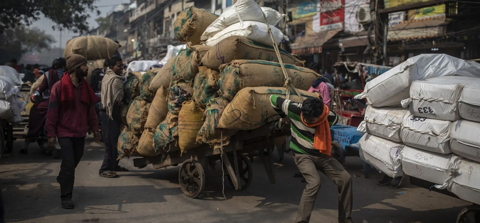 Nueva Delhi, India. Un trabajador intenta maniobrar su carro con alimentos a través de un mercado congestionado.