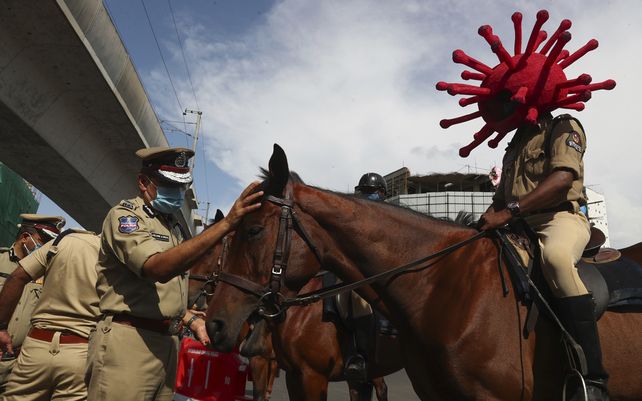Un policía monta a caballo con un casco con temática de virus durante una campaña de concientización sobre el COVID-19 en Hyderabad