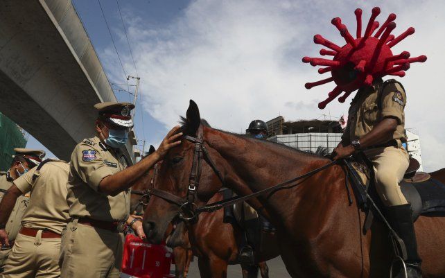 Un policía monta a caballo con un casco con temática de virus durante una campaña de concientización sobre el COVID-19 en Hyderabad, India.