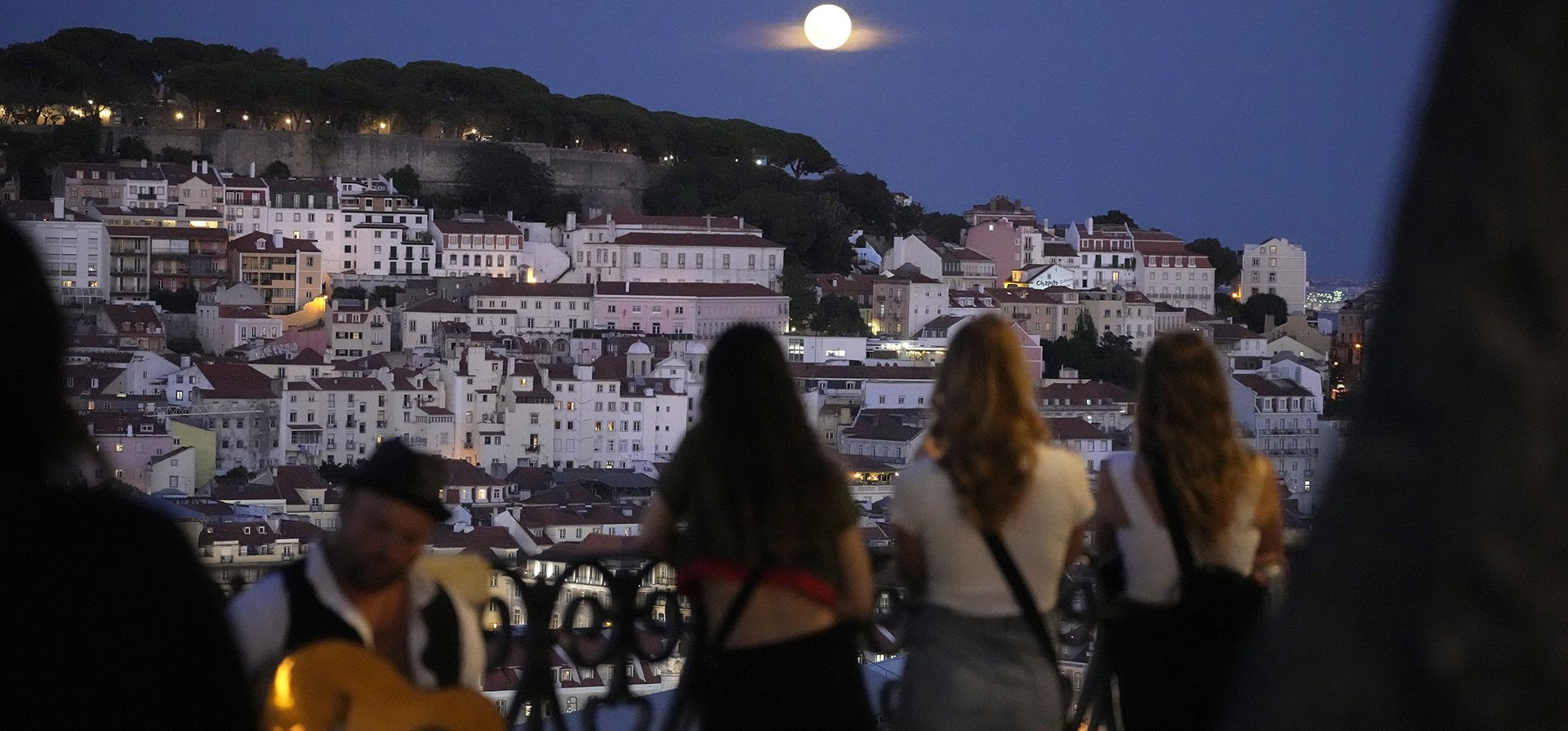 La gente observa una superluna elevarse sobre Lisboa, el miércoles 30 de agosto de 2023. (Foto AP/Armando Franca)