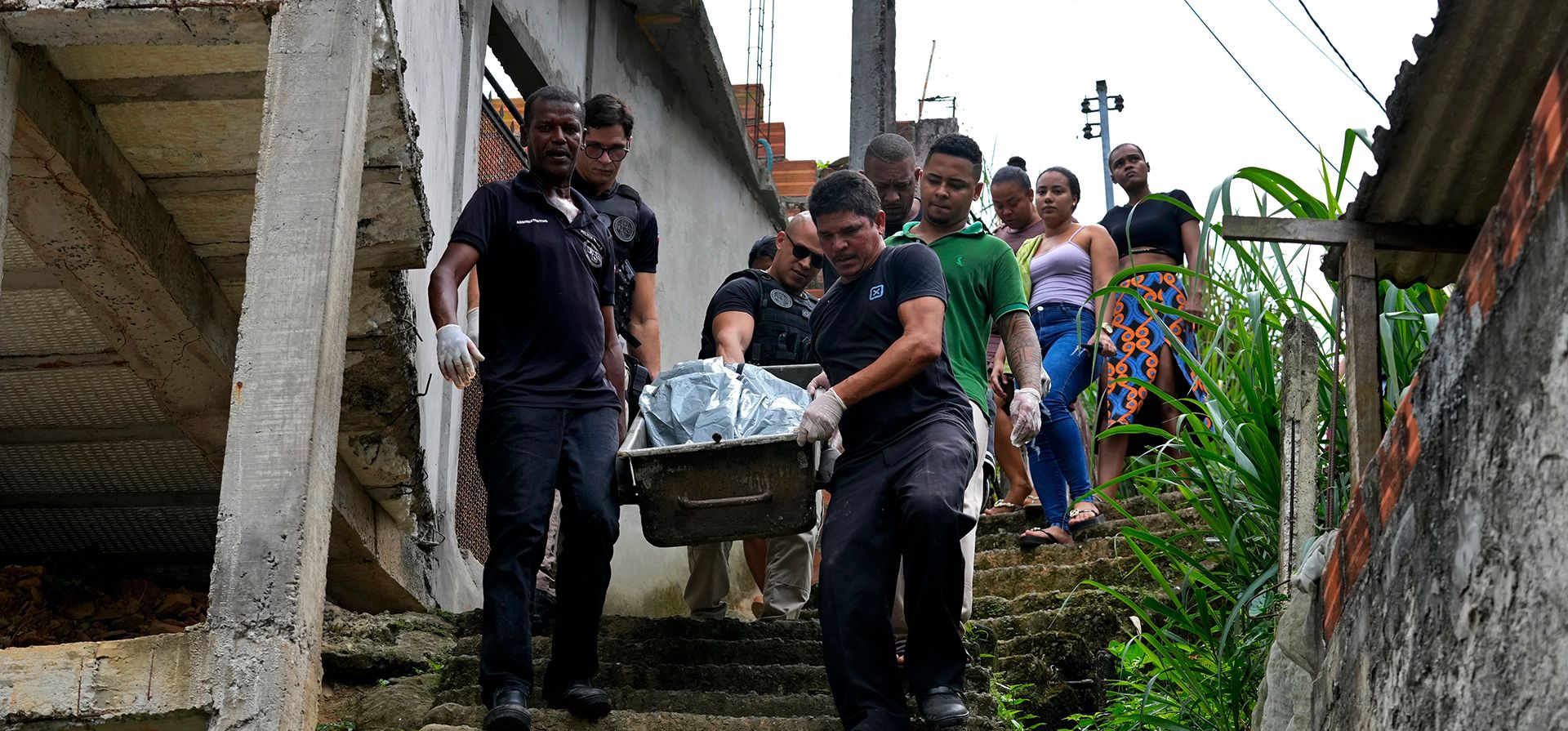Personal forense traslada el cuerpo de una persona fallecida durante enfrentamientos entre bandas criminales rivales, mientras los familiares de la víctima los siguen, en el barrio Jardim Esperança, a las afueras de Salvador, en el estado de Bahía, Brasil, el viernes 28 de agosto de 2026. (Foto AP/Eraldo Peres) Personal forense traslada el cuerpo de una persona fallecida durante enfrentamientos entre bandas criminales rivales, mientras los familiares de la víctima los siguen, en el barrio Jardim Esperança, a las afueras de Salvador, en el estado de Bahía, Brasil, el viernes 28 de agosto de 2026. (Foto AP/Eraldo Peres)