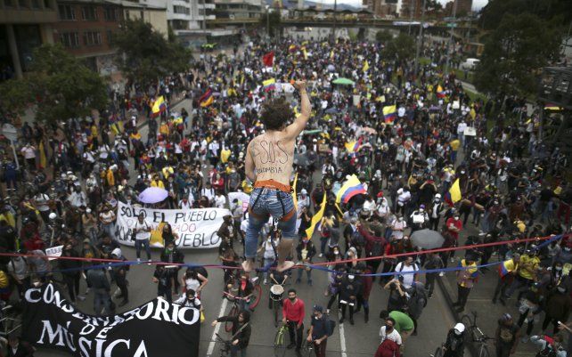 Un artista de cuerda floja hace equilibrio sobre una multitud que marcha durante una protesta contra el gobierno en Bogotá, Colombia.
