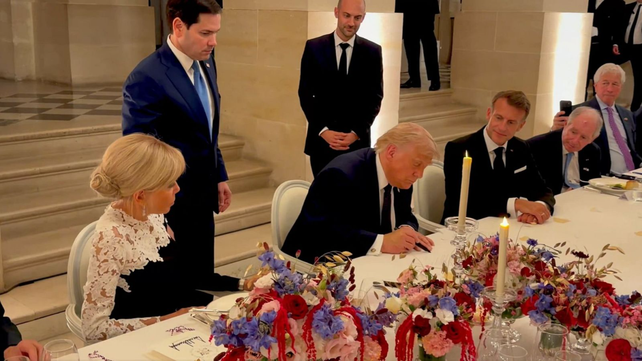 Donald Trump firmando el memorándum en el Palacio de Versalles